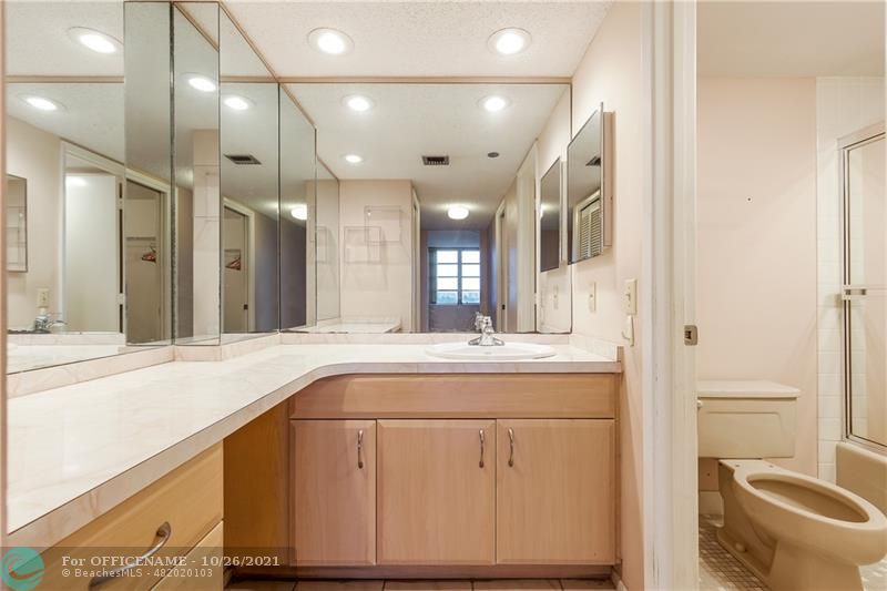 3520 Oaks Way, Unit 607 Pompano Beach, FL 33069 - Photo 16 of 31 a bathroom with a sink a toilet and a mirror
