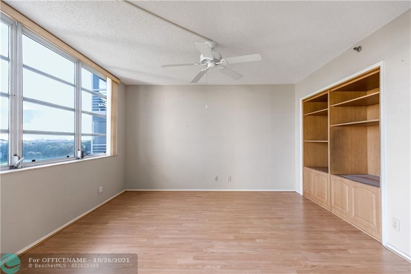 3520 Oaks Way, Unit 607 Pompano Beach, FL 33069 - Photo 18 of 31 an empty room with wooden floor and windows
