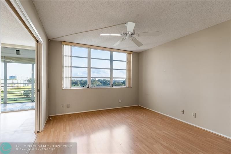 3520 Oaks Way, Unit 607 Pompano Beach, FL 33069 - Photo 19 of 31 an empty room with wooden floor and windows
