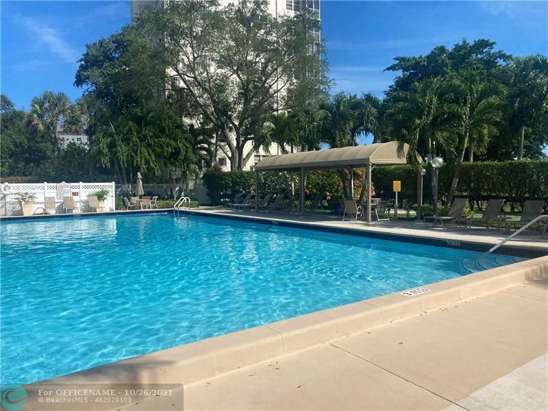 3520 Oaks Way, Unit 607 Pompano Beach, FL 33069 - Photo 21 of 31 a view of a swimming pool with lawn chairs and plants