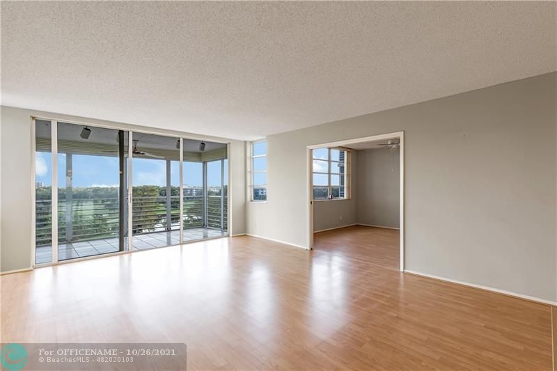 3520 Oaks Way, Unit 607 Pompano Beach, FL 33069 - Photo 4 of 31 wooden floor in an empty room with a window