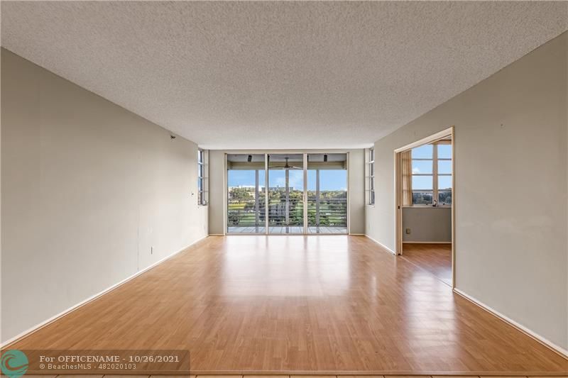 3520 Oaks Way, Unit 607 Pompano Beach, FL 33069 - Photo 5 of 31 wooden floor in an empty room with a window