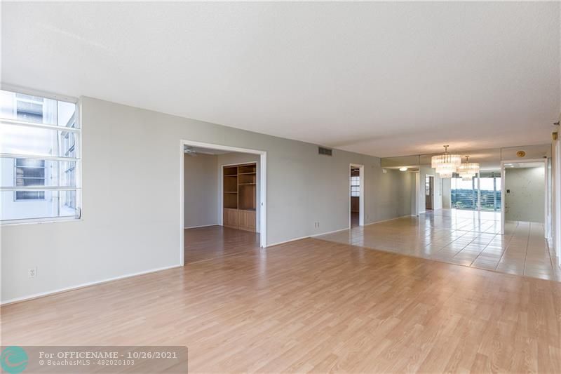 3520 Oaks Way, Unit 607 Pompano Beach, FL 33069 - Photo 8 of 31 a view of an empty room with wooden floor and a window