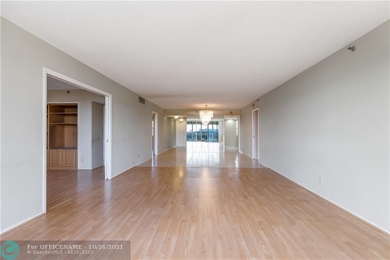 3520 Oaks Way, Unit 607 Pompano Beach, FL 33069 - Photo 9 of 31 a view of an empty room with wooden floor and a window
