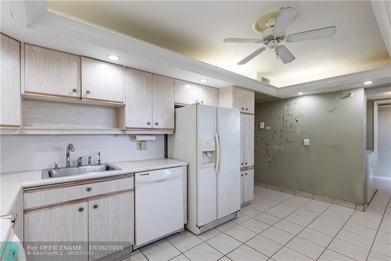 3520 Oaks Way, Unit 607 Pompano Beach, FL 33069 - Photo 10 of 31 a kitchen with white cabinets and white appliances
