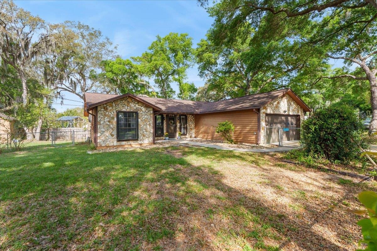 View of front of home featuring a garage and stone siding