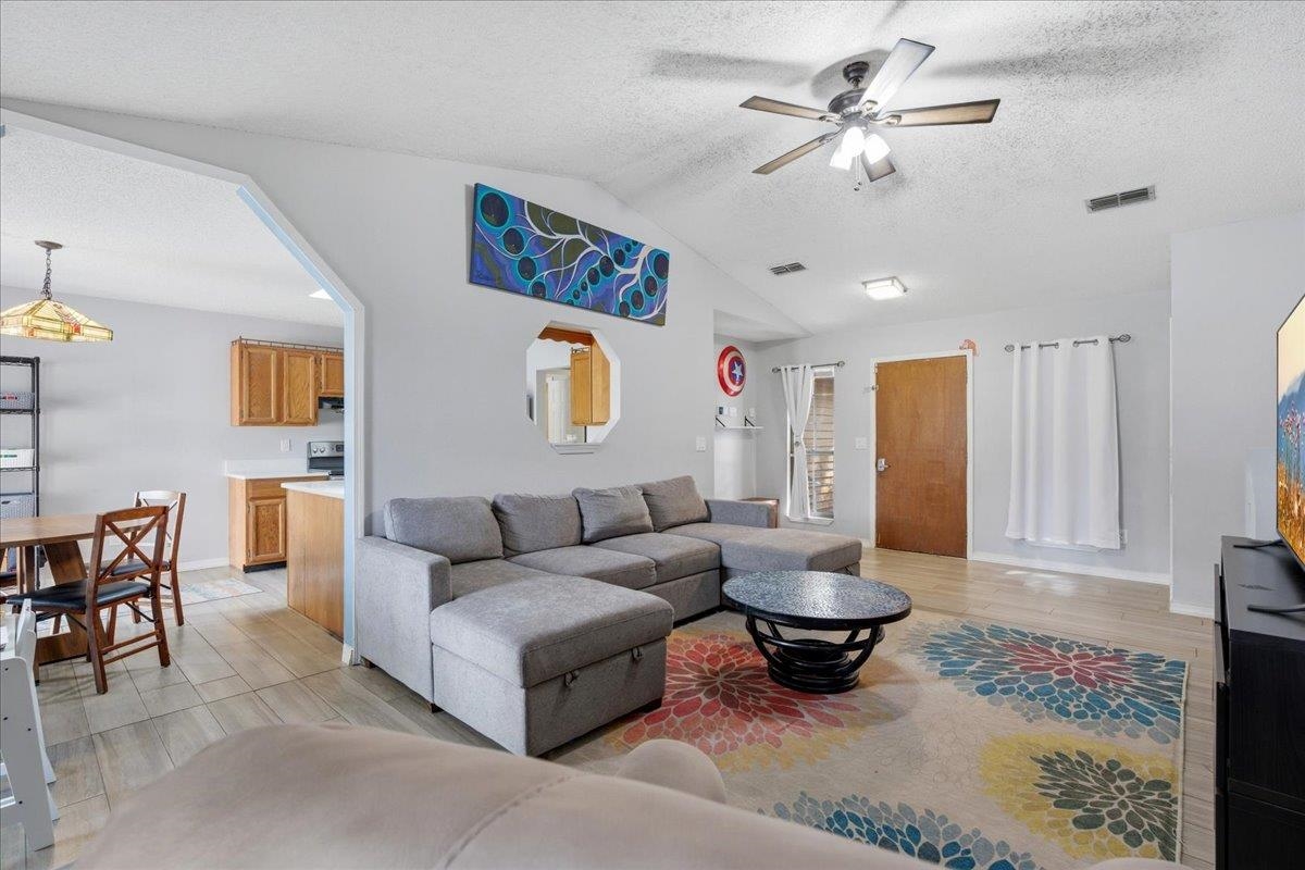 204 Queen Road St. Augustine, FL 32086 - Photo 12 of 55 Living room with a textured ceiling, light wood-style flooring, and ceiling fan