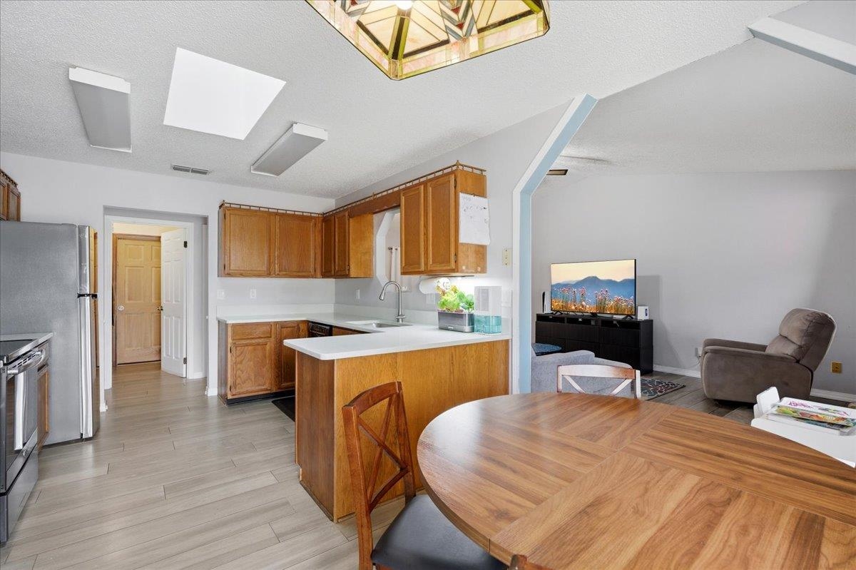 204 Queen Road St. Augustine, FL 32086 - Photo 15 of 55 Kitchen with light countertops, a peninsula, light wood-style flooring, stainless steel electric range, and a textured ceiling