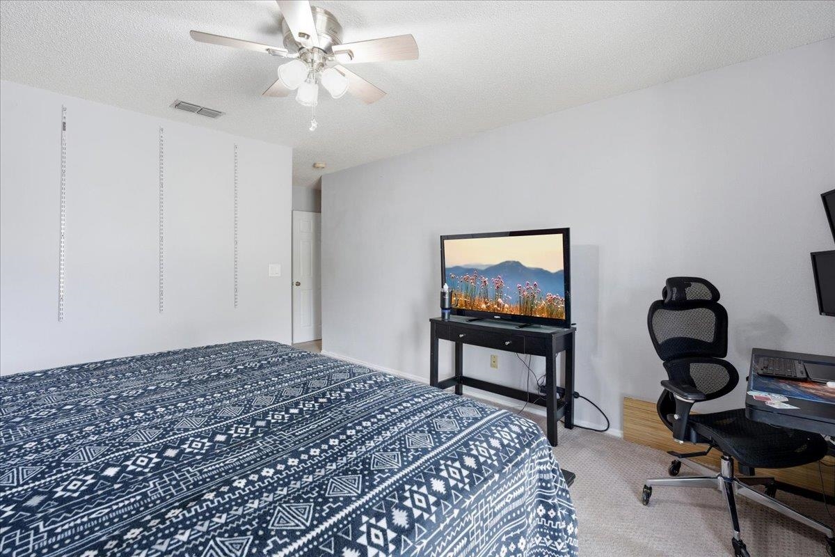 204 Queen Road St. Augustine, FL 32086 - Photo 21 of 55 Bedroom featuring an office area, a textured ceiling, light carpet, and a ceiling fan