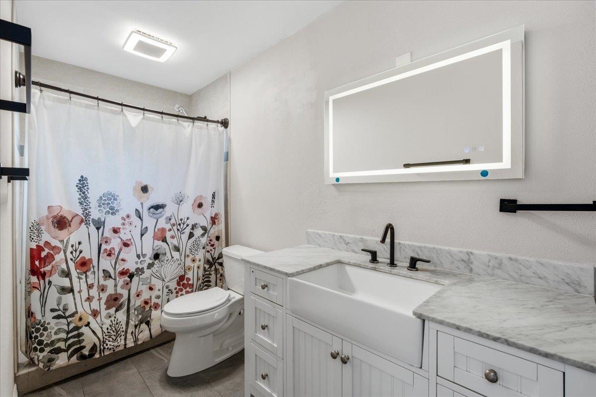 204 Queen Road St. Augustine, FL 32086 - Photo 22 of 55 Bathroom featuring vanity, curtained shower, a textured wall, and dark tile patterned floors