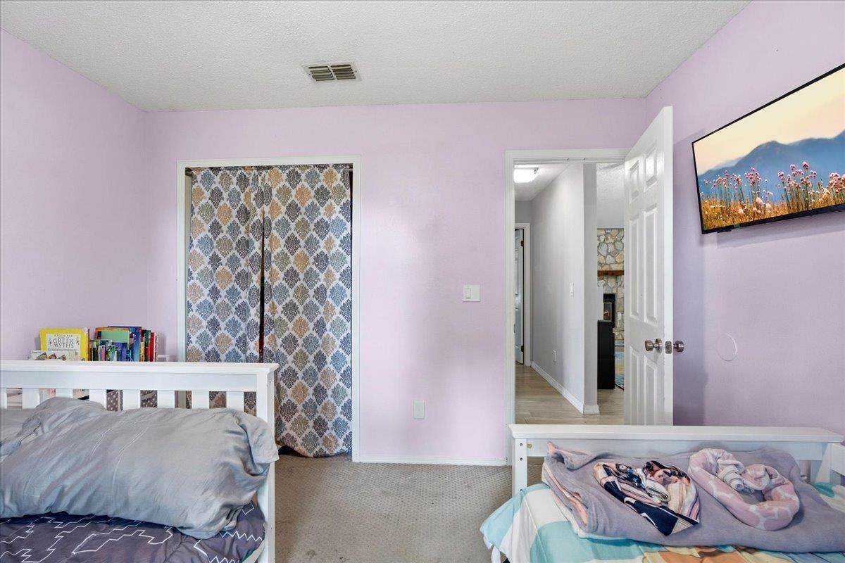 204 Queen Road St. Augustine, FL 32086 - Photo 25 of 55 Bedroom with light carpet and a textured ceiling