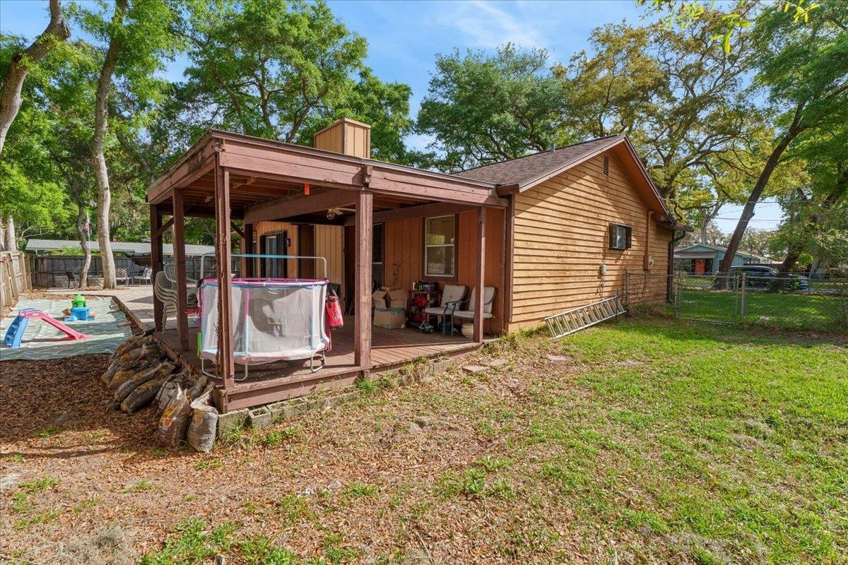 204 Queen Road St. Augustine, FL 32086 - Photo 36 of 55 Rear view of house with a fenced backyard, a wooden deck, and a chimney