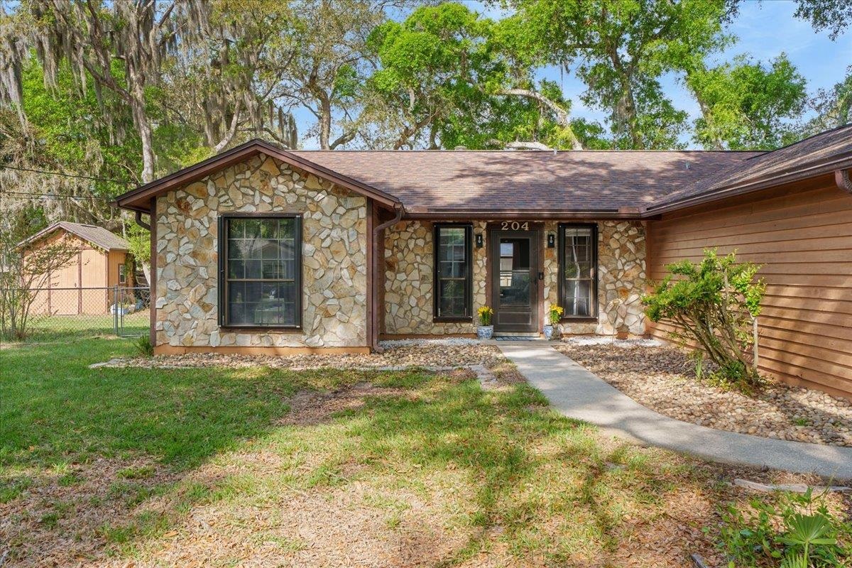 204 Queen Road St. Augustine, FL 32086 - Photo 5 of 55 View of front facade featuring stone siding and a shingled roof