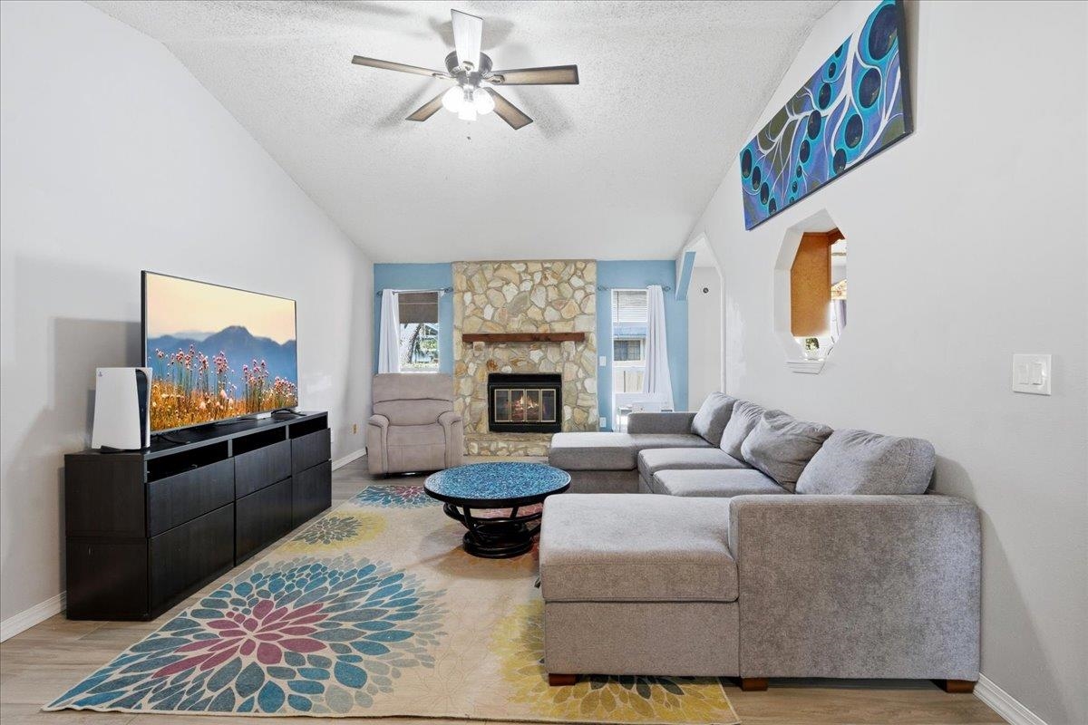 204 Queen Road St. Augustine, FL 32086 - Photo 8 of 55 Living area featuring ceiling fan, a stone fireplace, and light wood finished floors