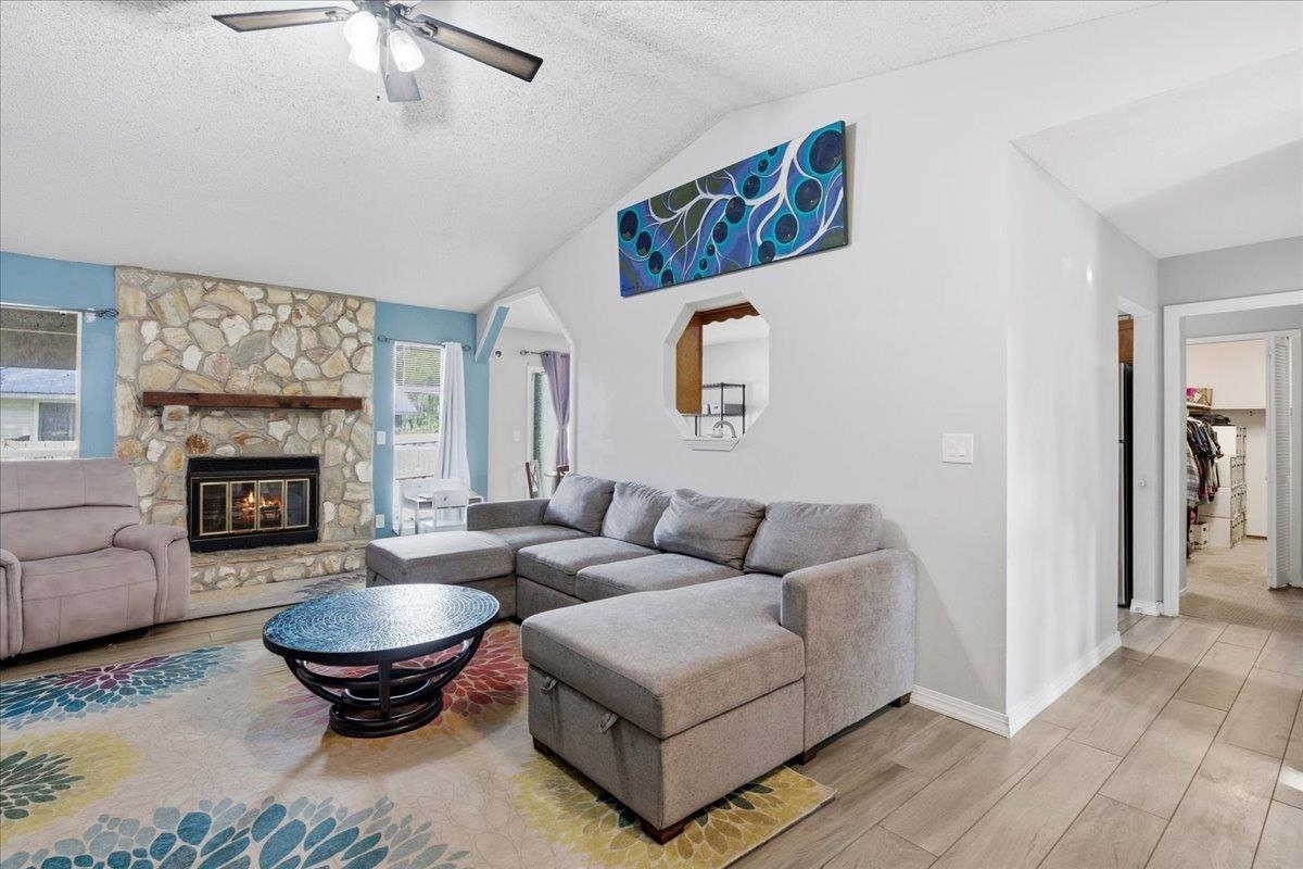 204 Queen Road St. Augustine, FL 32086 - Photo 9 of 55 Living area with wood finish floors, a stone fireplace, and ceiling fan