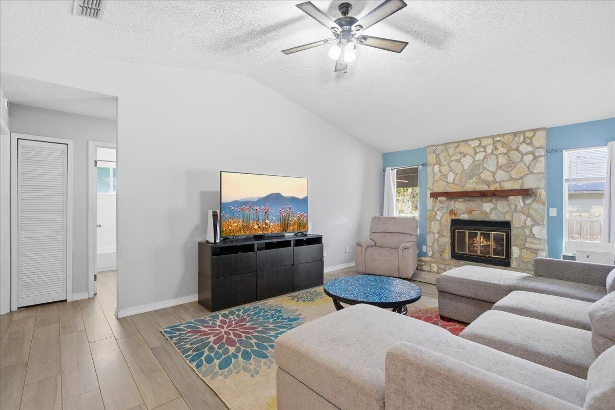 204 Queen Road St. Augustine, FL 32086 - Photo 10 of 55 Living area featuring light wood-style floors, a fireplace, and a ceiling fan