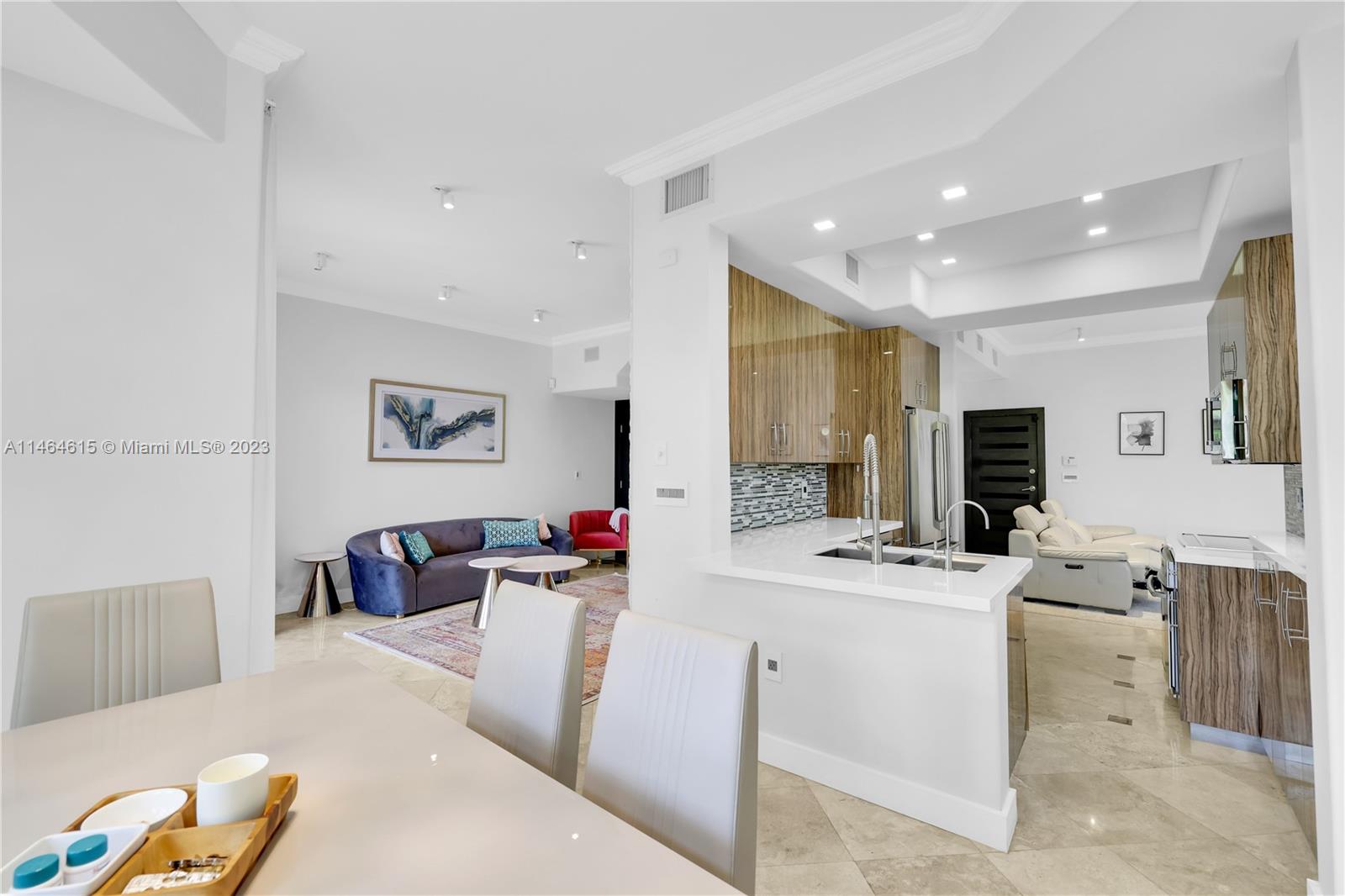 3015 Northeast 208th Street, Unit 3015 Aventura, FL 33180 - Photo 13 of 53 a room with stainless steel appliances kitchen island a stove a sink a dining table and chairs