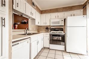 5626 Preston Oaks Road, Unit 39C Dallas, TX 75254 - Photo 28 of 38 Kitchen featuring white appliances, light countertops, white cabinets, and light tile patterned floors
