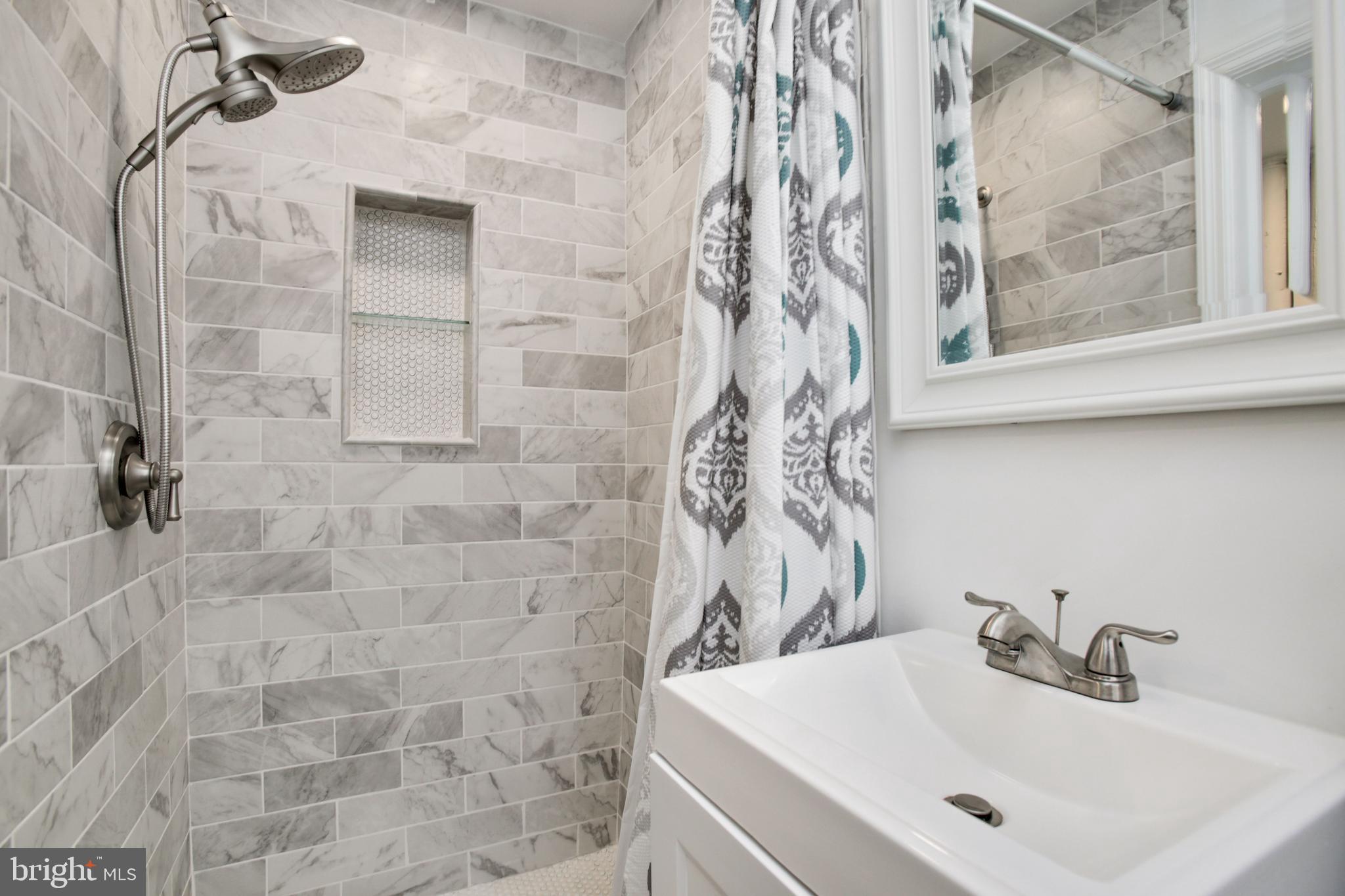 5021 West Hills Road Baltimore, MD 21229 - Photo 21 of 25 a bathroom with a sink and a mirror