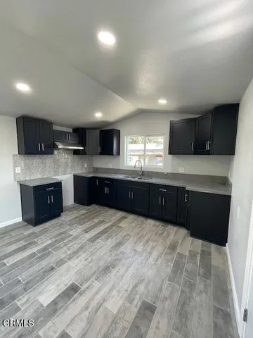 a large kitchen with a large counter top stainless steel appliances and cabinets