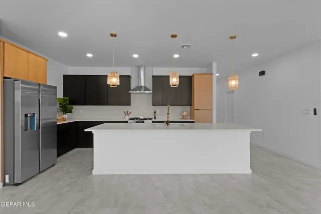 a kitchen with stainless steel appliances granite countertop a sink a stove and a refrigerator