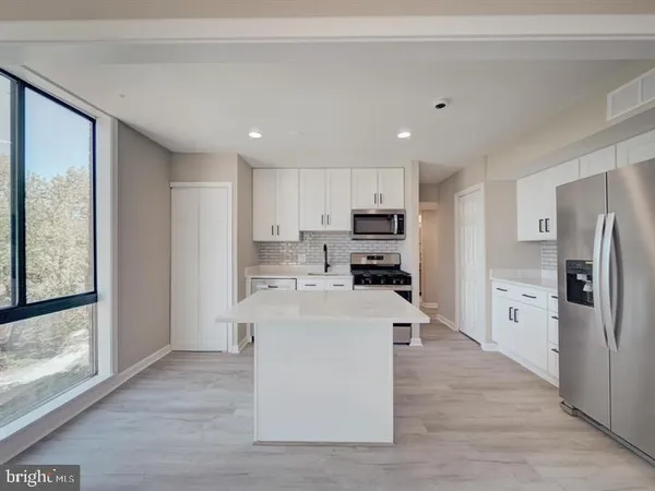 a kitchen with stainless steel appliances a refrigerator sink and cabinets