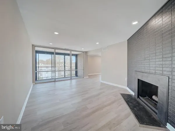a view of an empty room with a fireplace and a window