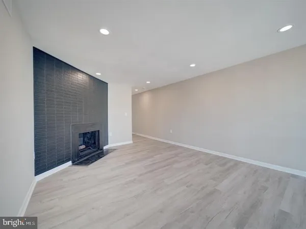 an empty room with wooden floor and fireplace