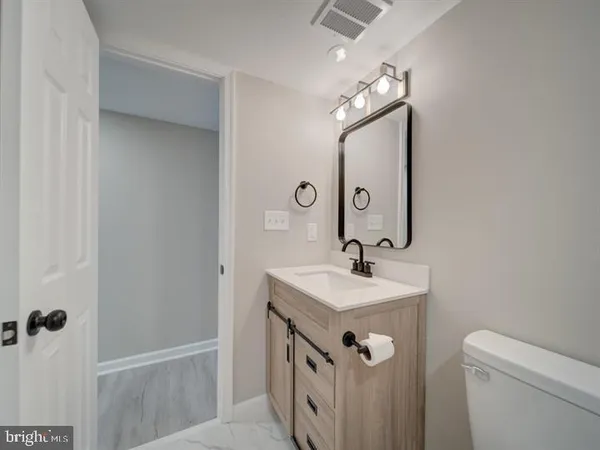 a bathroom with a sink a toilet and mirror