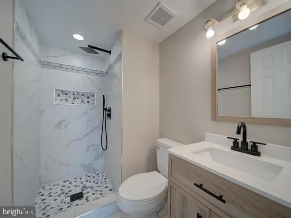 a bathroom with a sink a toilet and shower