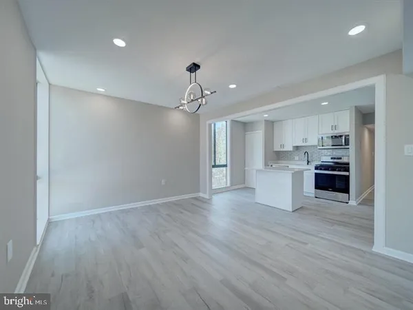 a view of kitchen with granite countertop cabinets and refrigerator