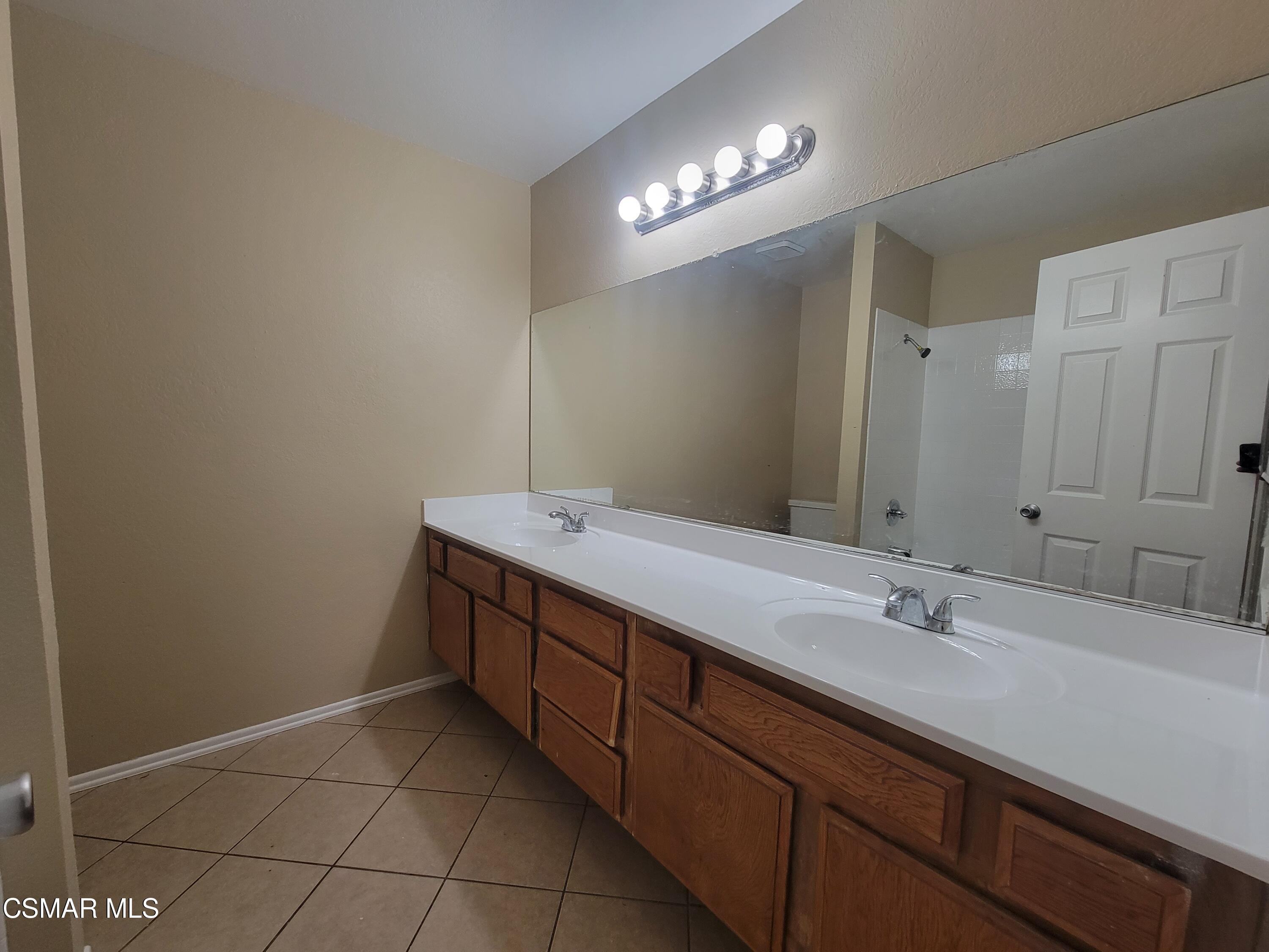 1200 Pasteur Drive Lancaster, CA 93535 - Photo 15 of 32 a bathroom with a sink vanity and a mirror