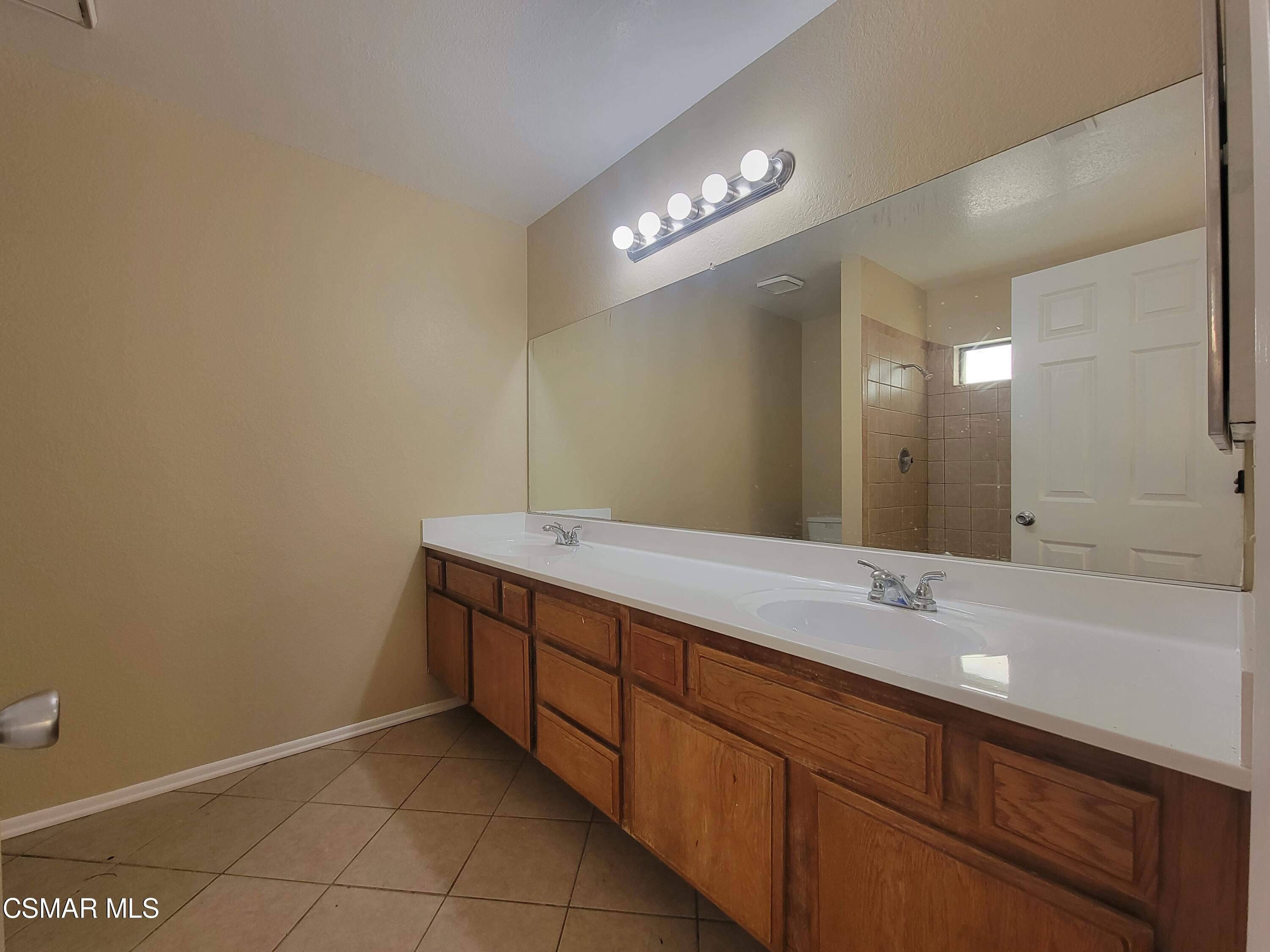 1200 Pasteur Drive Lancaster, CA 93535 - Photo 22 of 32 a bathroom with a sink vanity and a mirror