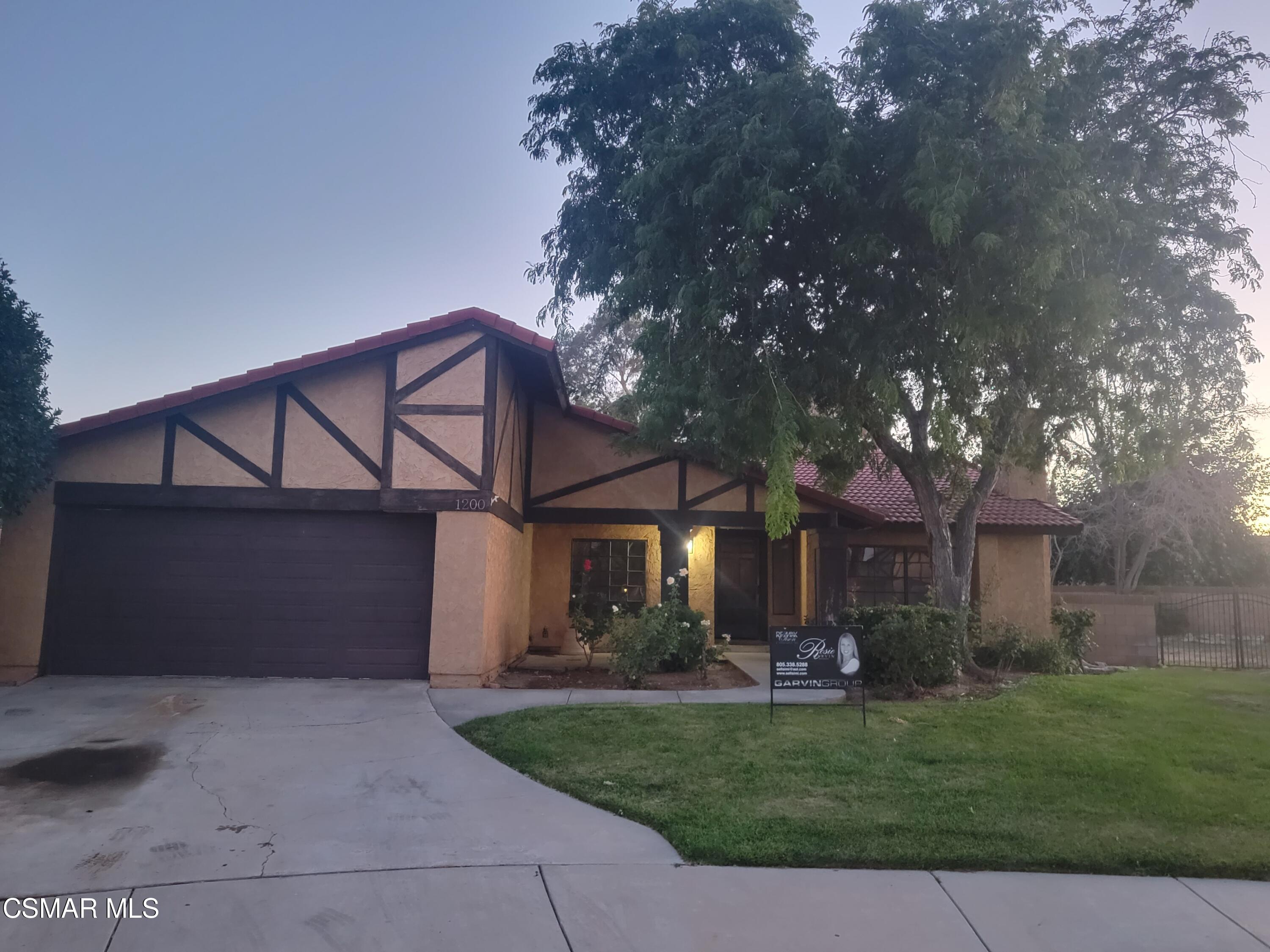 1200 Pasteur Drive Lancaster, CA 93535 - Photo 29 of 32 a front view of a house with a garden and trees