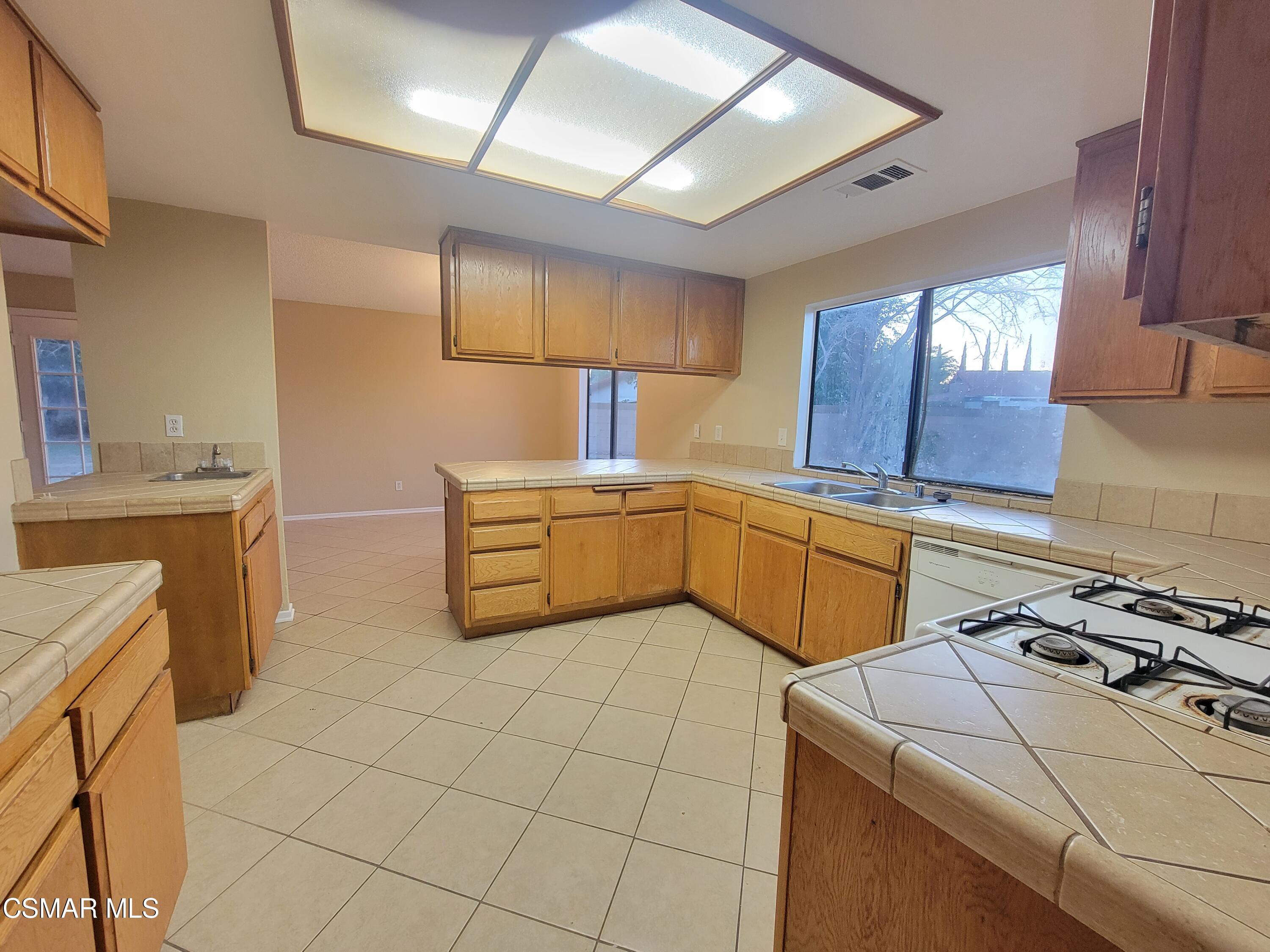 1200 Pasteur Drive Lancaster, CA 93535 - Photo 8 of 32 a kitchen with a stove a sink and a refrigerator