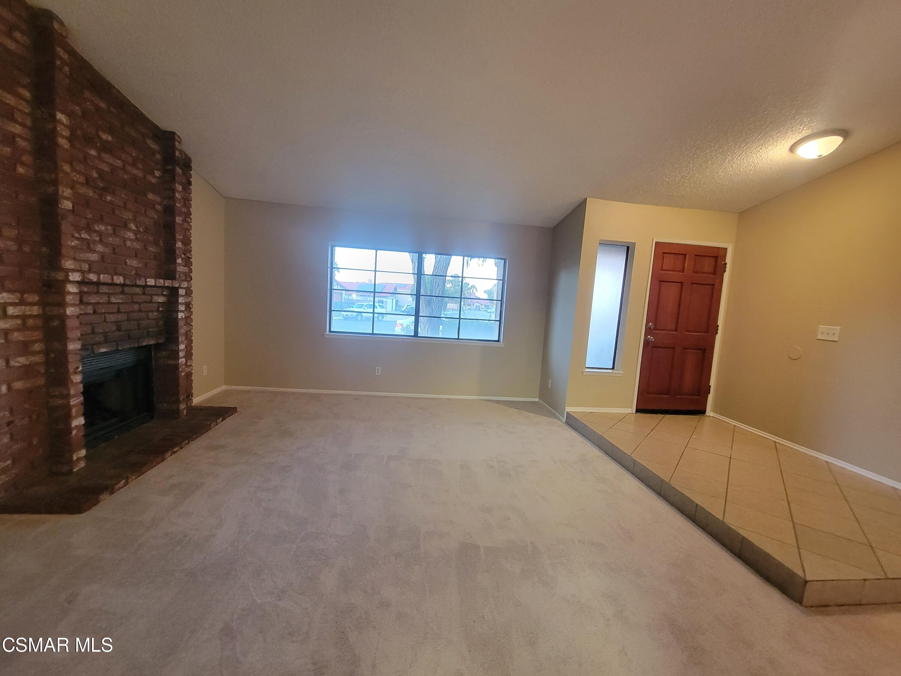1200 Pasteur Drive Lancaster, CA 93535 - Photo 9 of 32 a view of an empty room with a fireplace and a window