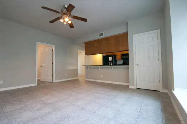 a view of a livingroom with a ceiling fan a ceiling fan and a kitchen