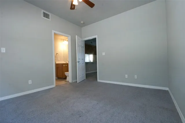 an empty room with closet and windows