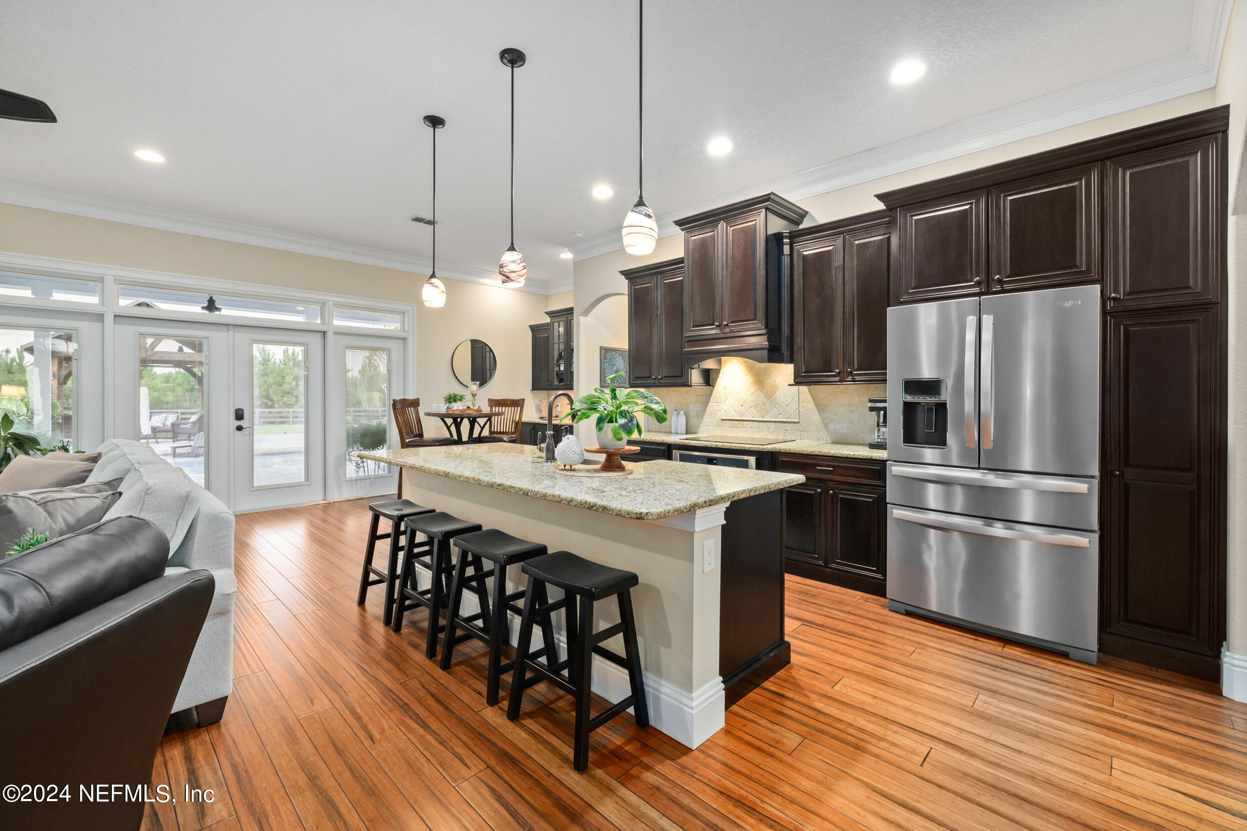 55278 Bartram Trail Callahan, FL 32011 - Photo 14 of 88 a kitchen with stainless steel appliances a kitchen island hardwood floor sink stove dining table and chairs