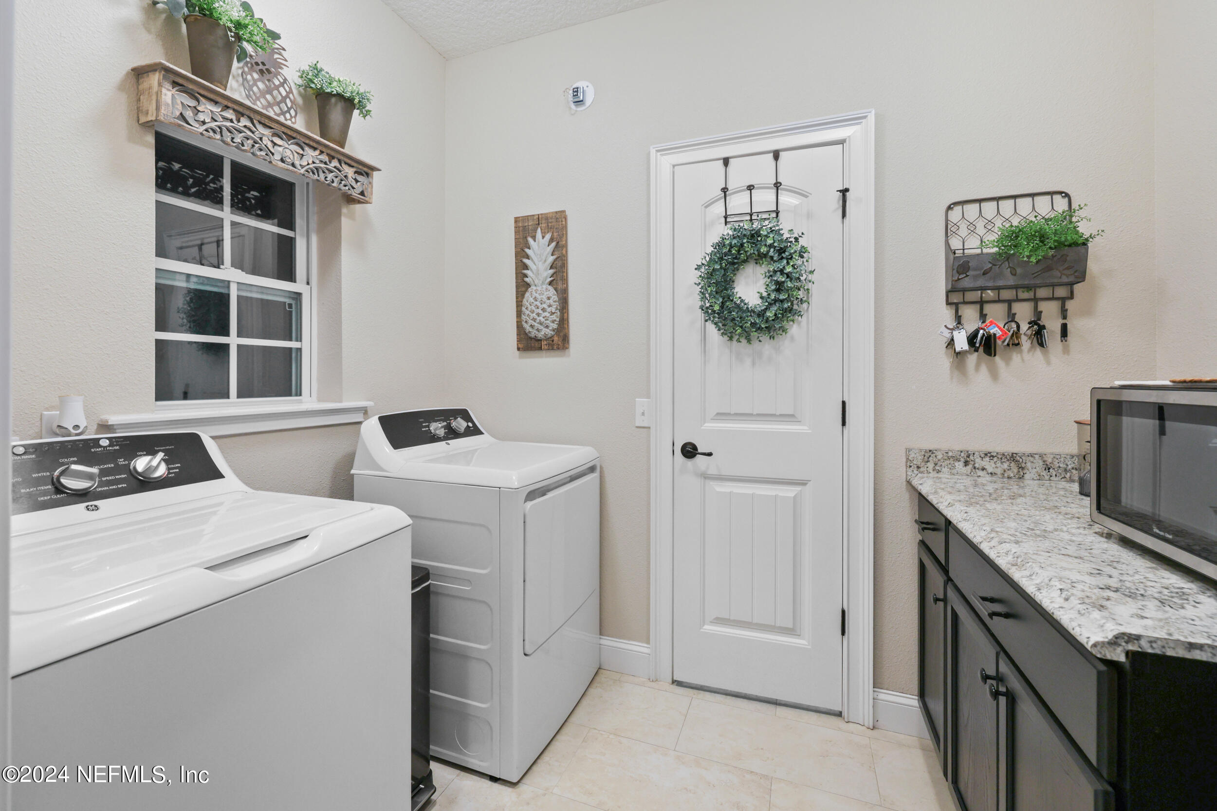 55278 Bartram Trail Callahan, FL 32011 - Photo 18 of 88 a utility room with cabinets washer and dryer