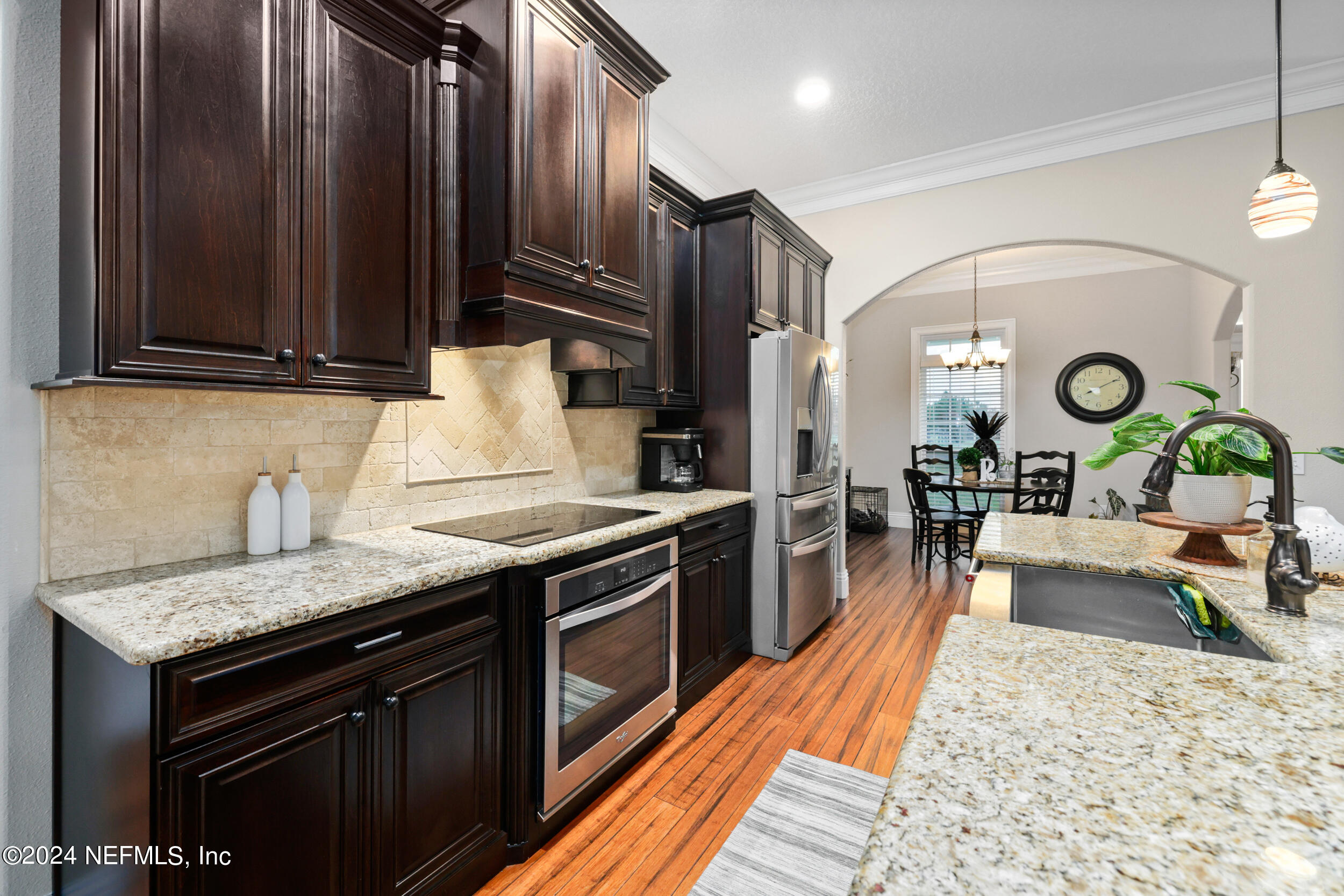 55278 Bartram Trail Callahan, FL 32011 - Photo 28 of 88 a kitchen with stainless steel appliances granite countertop a stove a sink dishwasher and cabinets with wooden floor