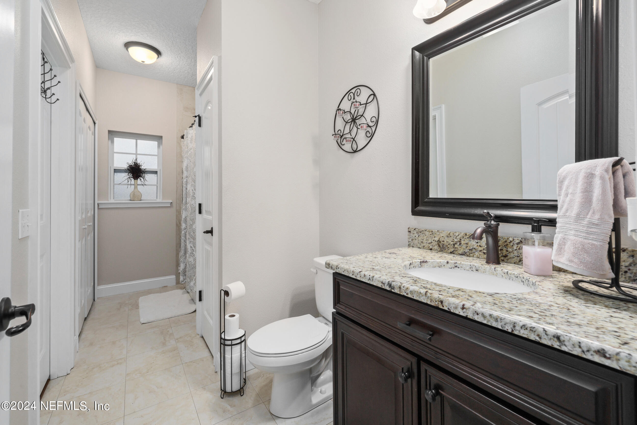 55278 Bartram Trail Callahan, FL 32011 - Photo 34 of 88 a bathroom with a granite countertop toilet sink and mirror