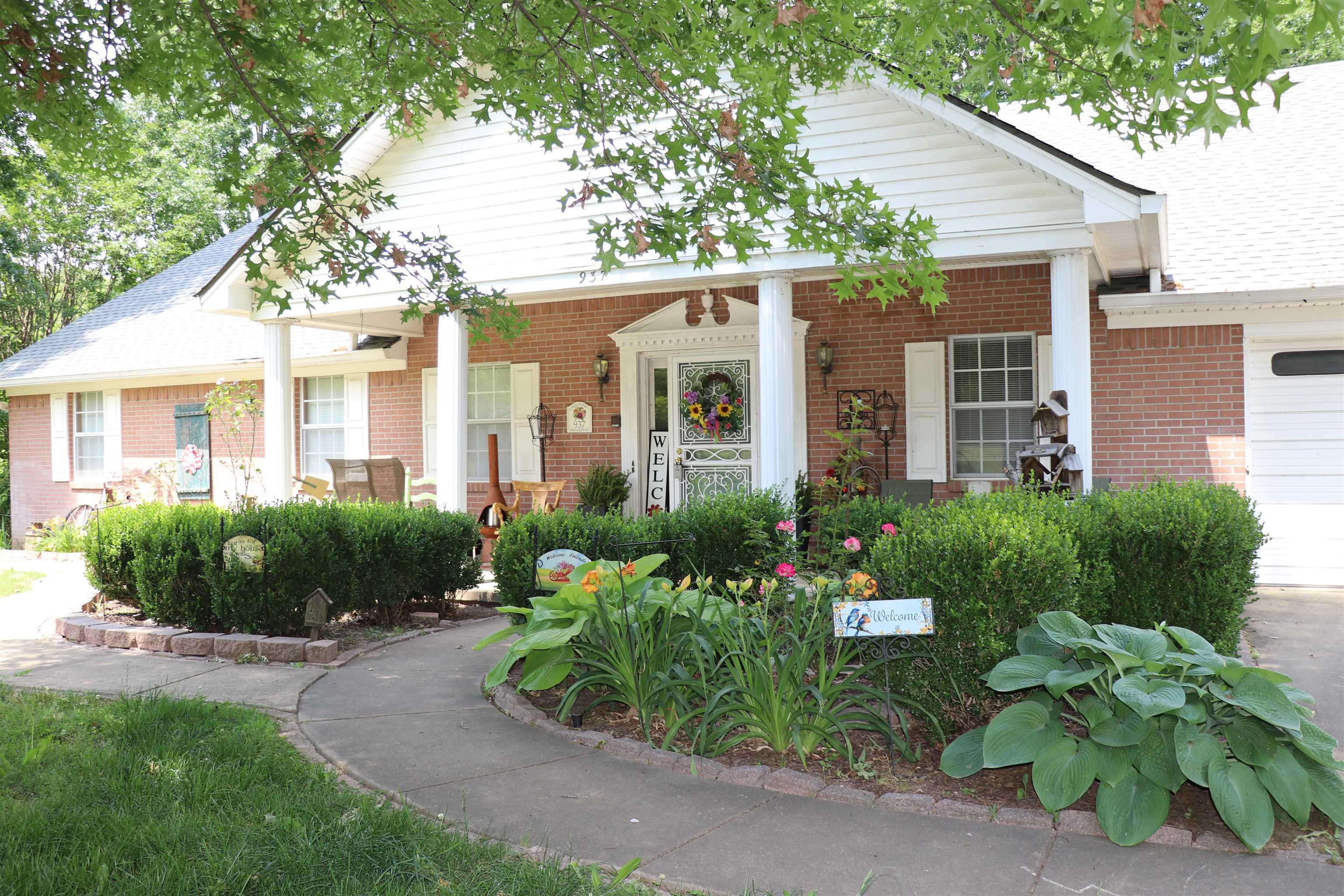Brick exterior with a covered porch featuring white columns