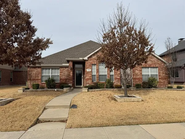 a view of a white house with a large tree in front of it