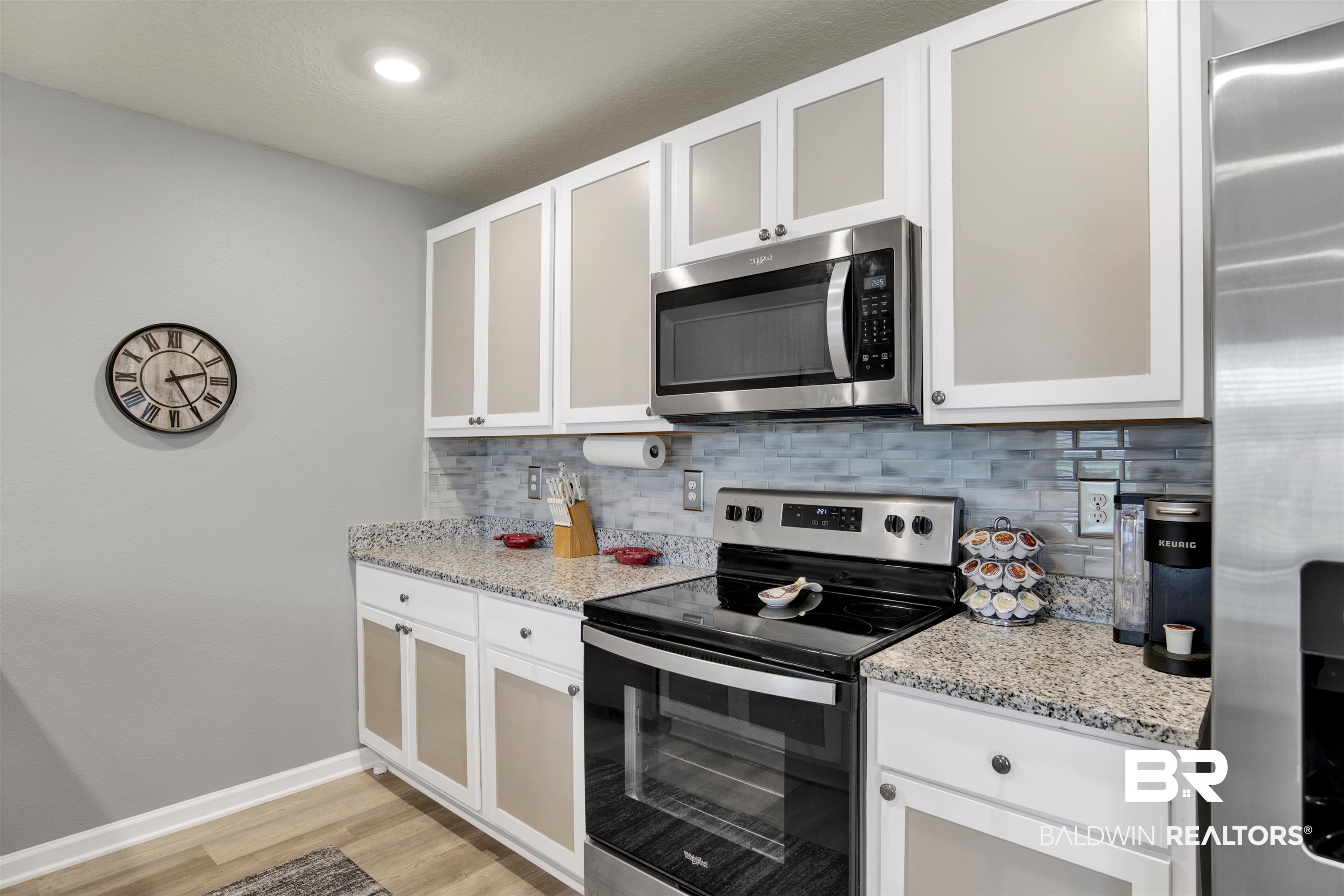 22348 Aleutian Avenue Foley, AL 36535 - Photo 10 of 32 Kitchen featuring stainless steel appliances, white cabinetry, light stone counters, and light wood-type flooring