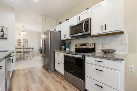 a kitchen with stainless steel appliances kitchen island granite countertop a stove a sink and a microwave