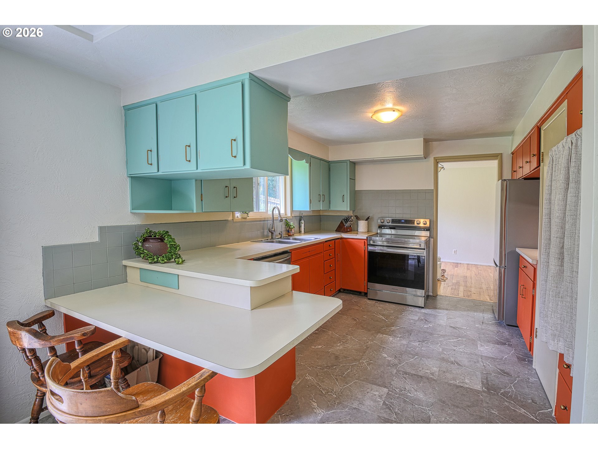 7077 Main Street Springfield, OR 97478 - Photo 6 of 34 a kitchen with stainless steel appliances kitchen island granite countertop a refrigerator oven a sink dishwasher and white cabinets with wooden floor