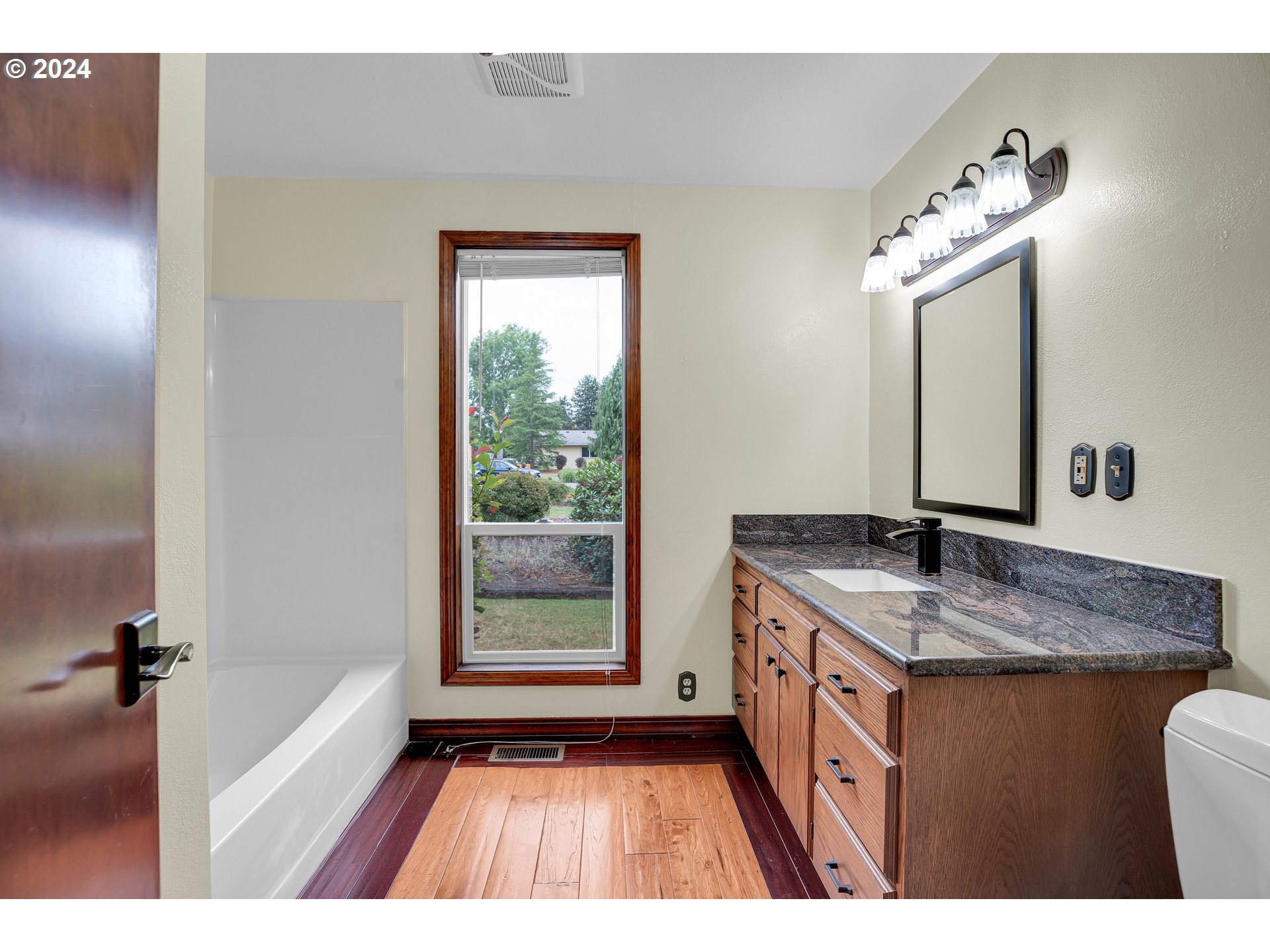 28930 Southeast Powell Valley Road Gresham, OR 97080 - Photo 20 of 38 a bathroom with a granite countertop sink mirror and a bathtub