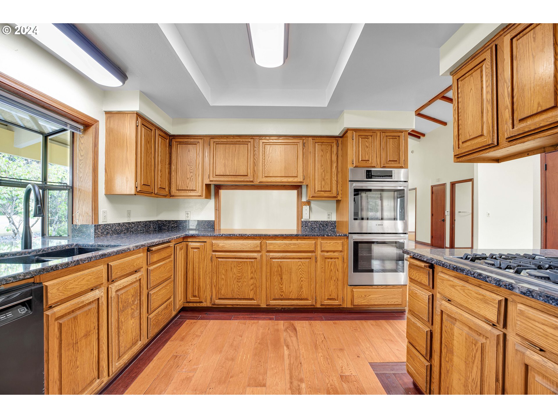 28930 Southeast Powell Valley Road Gresham, OR 97080 - Photo 5 of 38 a kitchen with stainless steel appliances granite countertop a stove sink and cabinets