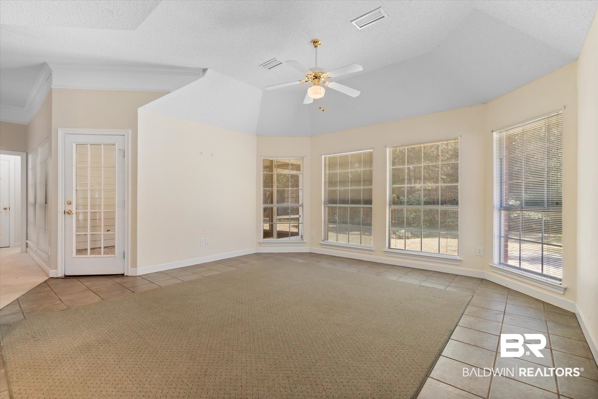 2220 Irongate Court Mobile, AL 36695 - Photo 9 of 20 Tiled spare room with a textured ceiling, visible vents, baseboards, vaulted ceiling, and a ceiling fan